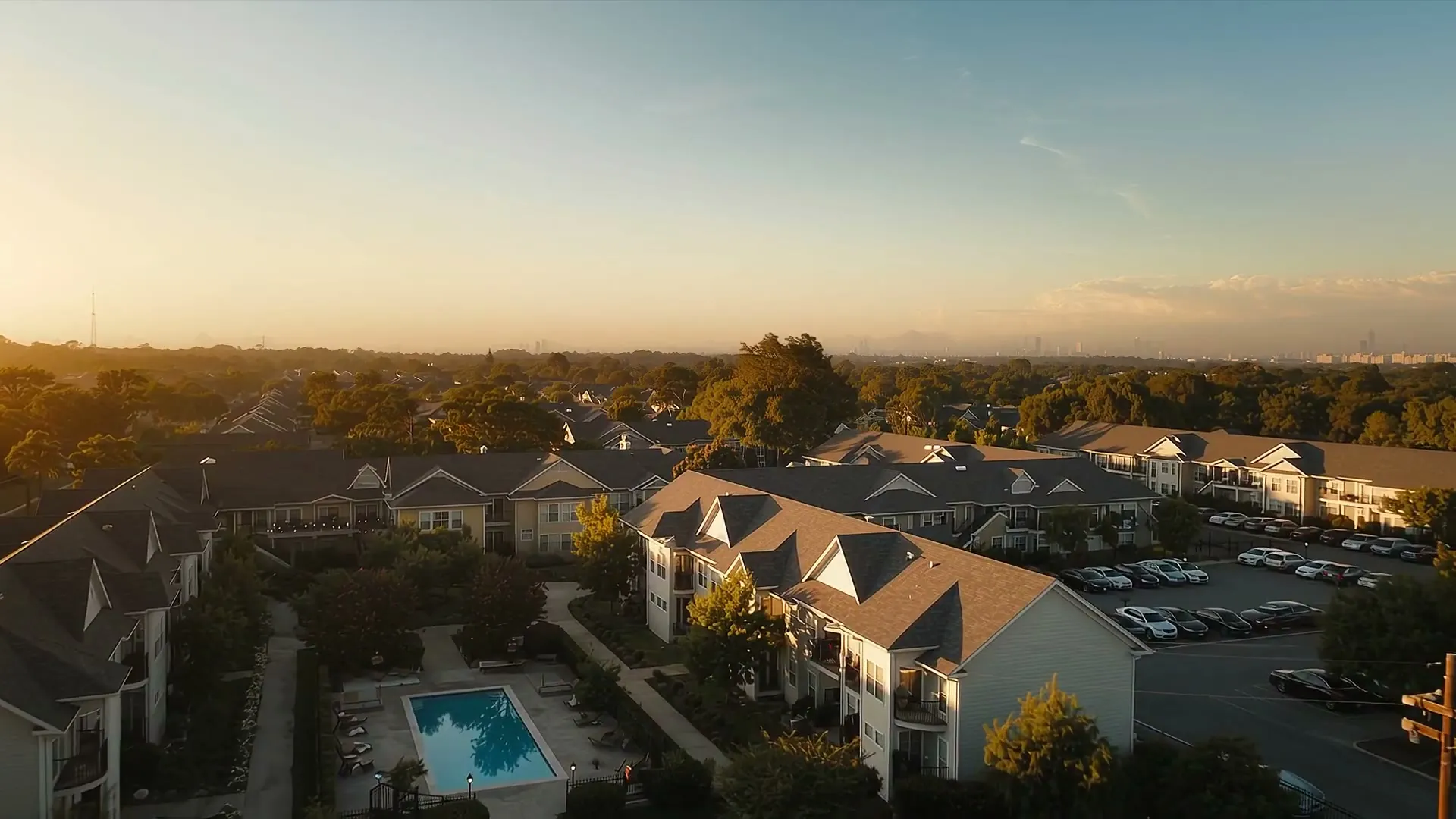 Apartment buildings and a pool from above at sunset